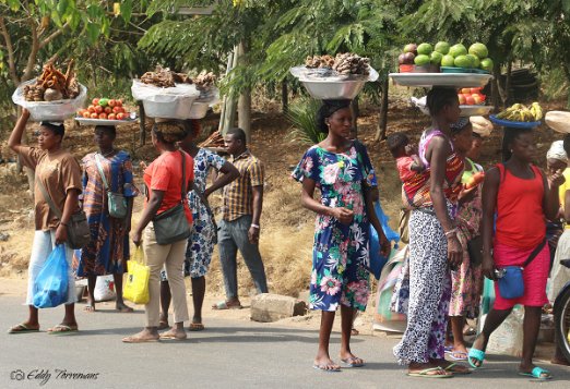 Lomé - Togo In Togo, as in many parts of West Africa, women carrying goods like fruits on their heads is a common and practical tradition. This method of transportation is...